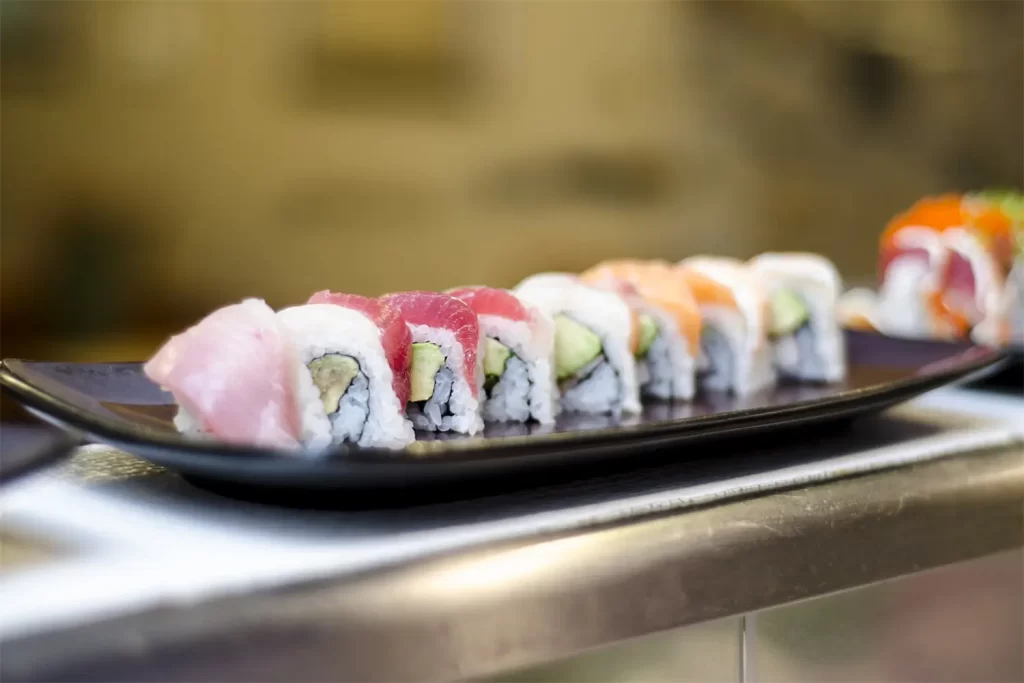 Colorful assorted sushi rolls on black plate at Otoro Sushi & Ramen, a Sushi Restaurant in Omaha