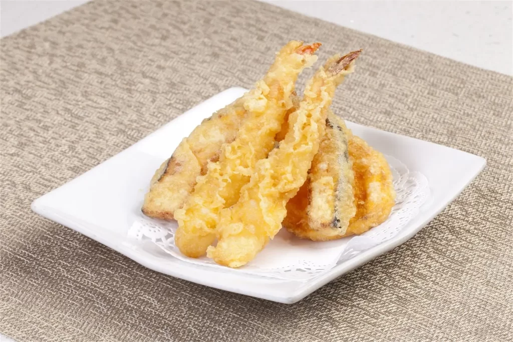 Crispy shrimp and vegetable tempura on white plate at Otoro Sushi & Ramen, a Sushi Restaurant in Omaha