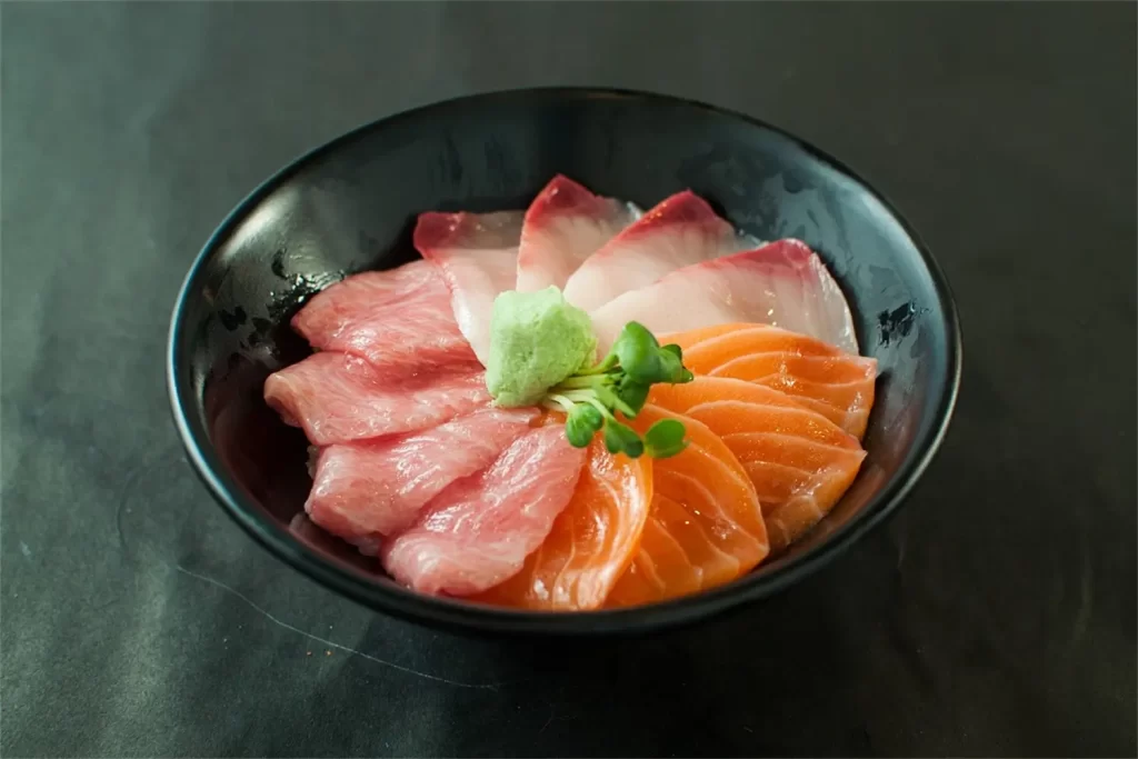 Mixed fresh sashimi in black bowl with wasabi at Otoro Sushi & Ramen, a Sushi Restaurant in Omaha